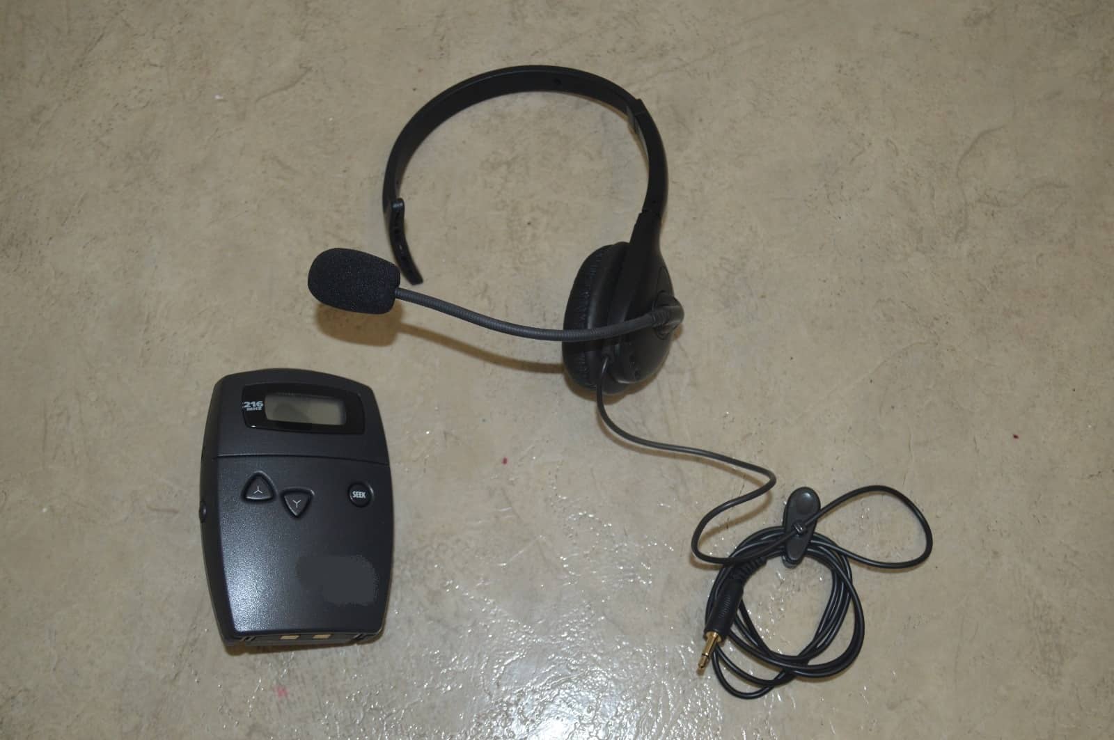 Portable wireless interpretation transmitter with single-ear headset for walking tours and mobile interpretation