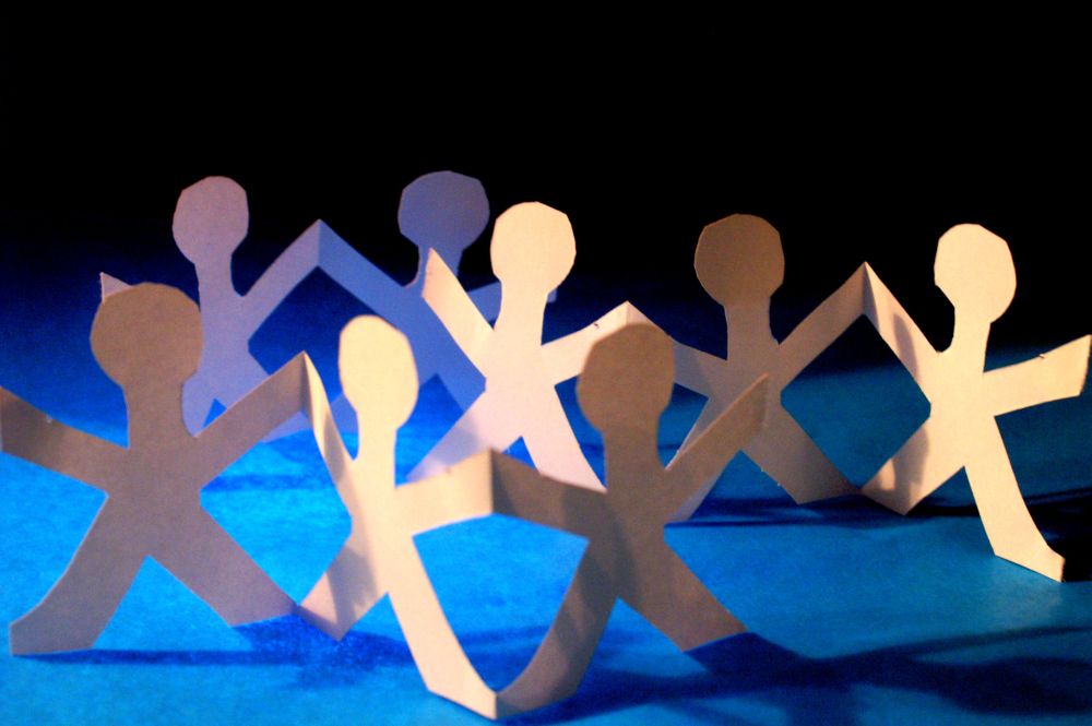 Paper cutout figures representing diverse cultures and cross-cultural body language communication